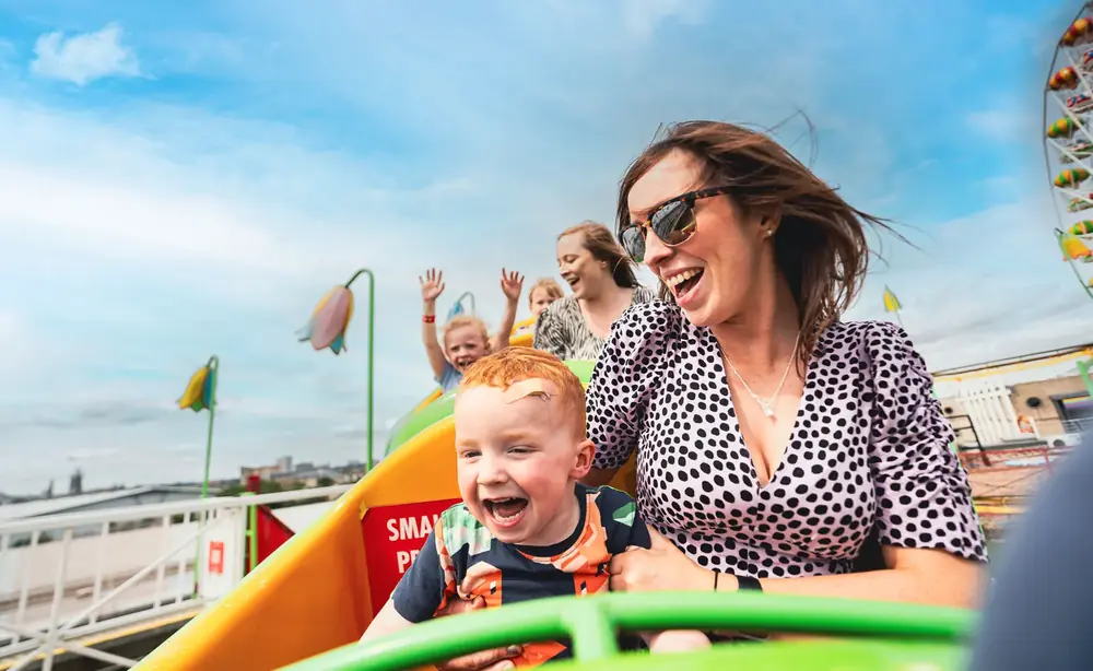 A mum and her child laughing on a ride at Codona’s Amusement Park, Aberdeen