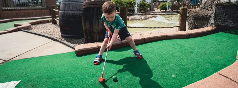A child lining up a putt